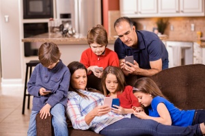 Family using cell phones at home. Children, parents. Technology.